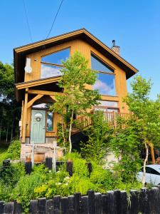 Casa de madera con puerta verde en Ohisama House en Rusutsu