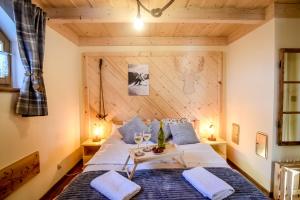 ein Schlafzimmer mit einem Bett mit einer Holzwand in der Unterkunft Tatra Góral Ski Apartament in Murzasichle