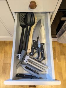 eine Schublade mit Messern und anderen Küchenutensilien in der Unterkunft Guildford Station with Parking in Stoughton