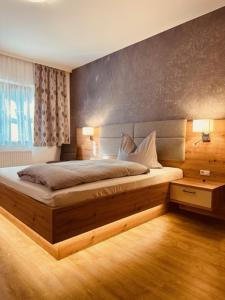 ein Schlafzimmer mit einem großen Bett und einem Fenster in der Unterkunft Almtalhotel Appartements in Pettenbach in Pettenbach