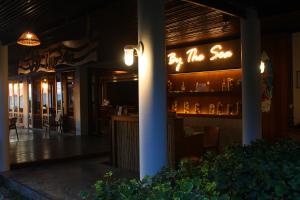 a restaurant with a neon sign on the wall at Deva Beach Resort Samui in Choeng Mon Beach