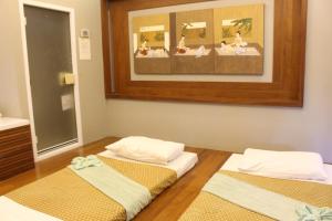 two beds in a room with a painting on the wall at Deva Beach Resort Samui in Choeng Mon Beach