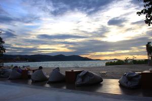 a group of people sitting at tables on the beach at Deva Beach Resort Samui in Choeng Mon Beach