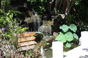 a fountain in a garden with a waterfall at Deva Beach Resort Samui in Choeng Mon Beach