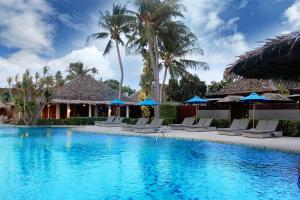 a pool at a resort with chairs and umbrellas at Deva Beach Resort Samui in Choeng Mon Beach