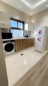a kitchen with a white refrigerator and a sink at وسن الشرق in Dammam