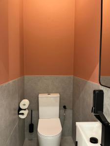 a bathroom with a toilet and a sink at Central Gallery Apartment in Debrecen +15 photos