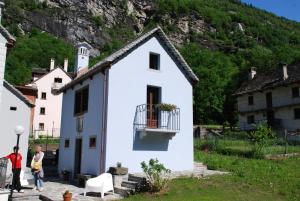uma casa branca com uma varanda e uma montanha em Ca' del Borgo em Cadarese