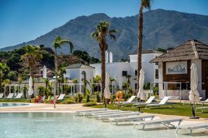 un complexe avec une piscine, des chaises et des palmiers dans l'établissement LAE28BI - Mirador de Estepona hills by Roomservice, à Estepona