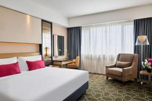 une chambre d'hôtel avec un lit et une chaise dans l'établissement Wyndham Acmar Klang, à Klang