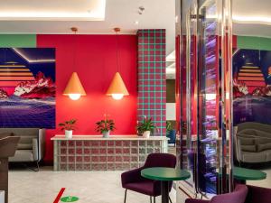 a restaurant with colorful walls and tables and chairs at ibis Styles Krasnaya Polyana in Estosadok