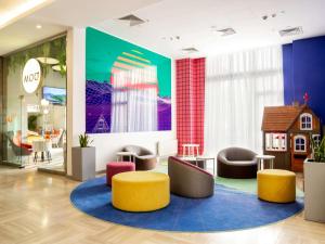 a lobby with chairs and a toy house on the wall at ibis Styles Krasnaya Polyana in Estosadok