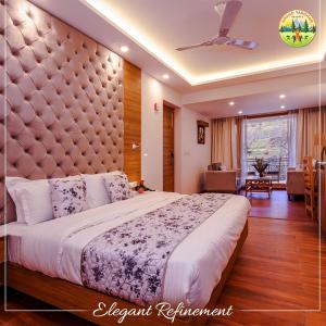 a bedroom with a large bed with a large headboard at Anand Vardhan Resorts in Manāli