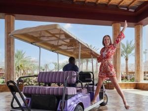 a woman is standing on a golf cart at Mövenpick Resort & Spa Tala Bay Aqaba in Aqaba
