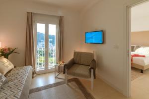 a bedroom with a bed and a chair and a television at Hotel Moresco in Santa Teresa Gallura