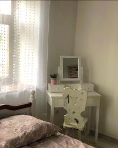 um quarto com uma secretária com um espelho e uma cadeira em Tulipános Vendégház em Igrici