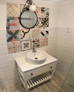 a bathroom with a sink and a mirror at Tulipános Vendégház in Igrici