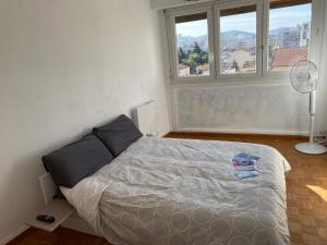 a bedroom with a bed and a window and a fan at Appartement calme Stade/plage in Marseille