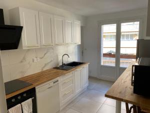 a kitchen with white cabinets and a sink at Appartement calme Stade/plage in Marseille