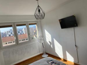 a room with a fan and a tv and windows at Appartement calme Stade/plage in Marseille