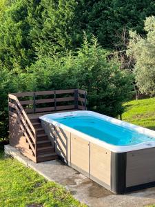 una bañera de hidromasaje con una valla de madera alrededor en Caserio Goitisolo - piscina jacuzzi climatizada, gimnasio y sauna en el corazón de la reserva de la biosfera de Urdaibai, en Gautegiz Arteaga