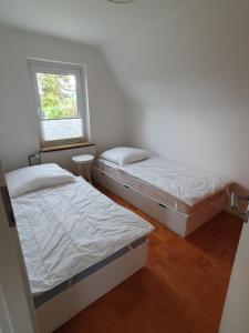 two beds in a small room with a window at FeWo-Schnoor in Lübeck