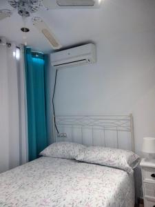 ein Schlafzimmer mit einem Bett mit einer weißen Tagesdecke in der Unterkunft Casa Sevilla in Mairena del Aljarafe + 11 Fotos