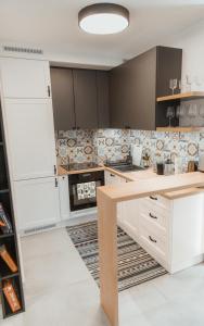a kitchen with white cabinets and a wooden island at Bike&Relax Szyndzielnia in Bielsko-Biała