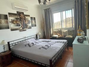 a bedroom with a large bed and a couch at Casira, studio's en kamers, Viñuela, Costa Del Sol in Viñuela