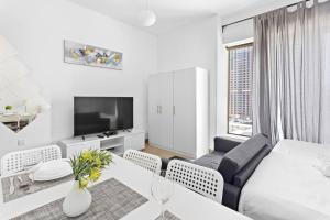 a living room with a bed and a table and a tv at StoneTree - Elegant Studio in Peaceful Community in Dubai