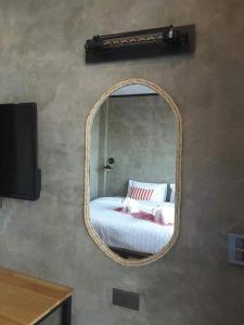 a mirror on a wall with a bed in a room at Lanta Chaolay in Ko Lanta