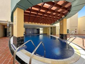 a large swimming pool in a large building at StoneTree - Elegant Studio in Peaceful Community in Dubai