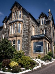 a stone building with a sign on the front of it at Glenburnie House in Oban