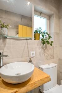 ein Badezimmer mit einem weißen Waschbecken und einem WC in der Unterkunft Casa do Sol in Colares