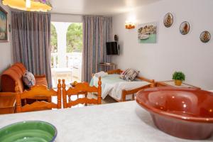 a living room with a bedroom with a bed at Atalaya Bosque Apartamentos in Paguera