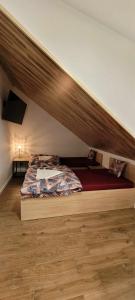 een bed in een kamer met een houten vloer bij Noclegi w Dawnej Łaźni in Żarki