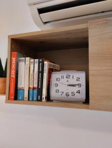 a clock sitting on a shelf with books at Apartamentos Canana de Vega in Flix