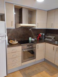 a kitchen with white cabinets and a stove top oven at Apartamentos Canana de Vega in Flix