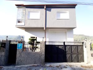 uma casa com um portão e uma cerca em CASA MIRADOR REZA Alojamiento Termas em Ourense