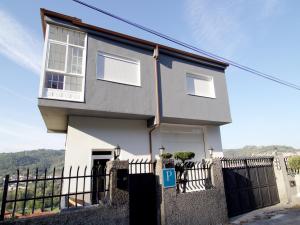uma casa branca com uma cerca à frente. em CASA MIRADOR REZA Alojamiento Termas em Ourense