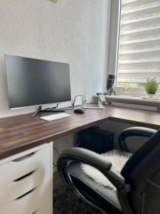 una scrivania con monitor e sedia di Zentrale gemütliche Wohnung a Saarbrücken