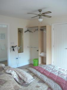 1 dormitorio con 1 cama y ventilador de techo en Templemoyle Farm Cottages, en Campsey