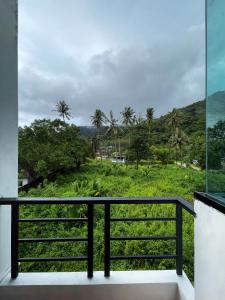 a balcony with a view of a lush green field at Kefir Phuket in Kamala Beach +11 photos