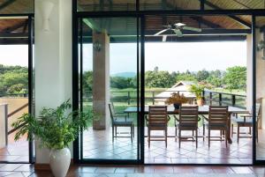 een patio met een tafel en stoelen en uitzicht bij Chalala Tropical Garden and Villas in Ban Pa Lan