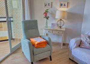 ein Wohnzimmer mit einem Stuhl und einem Tisch mit einer Lampe in der Unterkunft Skol 242 Excellent One Bedroom Apartment with Sea Views in Marbella