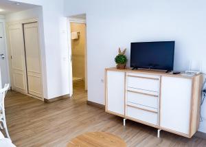 uma sala de estar com televisão numa cómoda em Skol 242 Excellent One Bedroom Apartment with Sea Views em Marbella