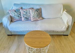 マルベーリャにあるSkol 242 Excellent One Bedroom Apartment with Sea Viewsのソファ(枕付)、テーブルが備わります。