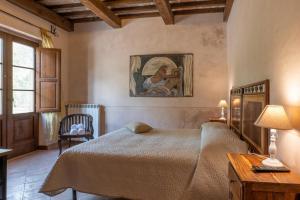 ピティリアーノにあるAgriturismo Tenuta Roccacciaのベッドルーム1室(ベッド1台付)が備わります。壁には絵画が飾られています。