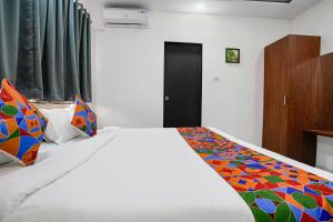 Un dormitorio con una cama con una manta de colores. en FabHotel Fortuna Inn, en Navi Mumbai