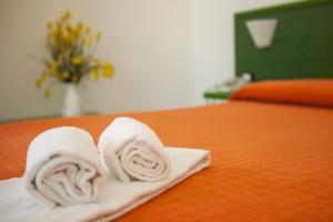 a white towel laying on top of a bed at Hotel Piccada in Palau